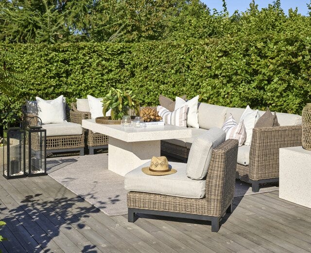 Elegant loungegruppe ute i kunstrotting og beige tesktil med sofabord i terrazzo fra Halvor Bakke hagemøbler