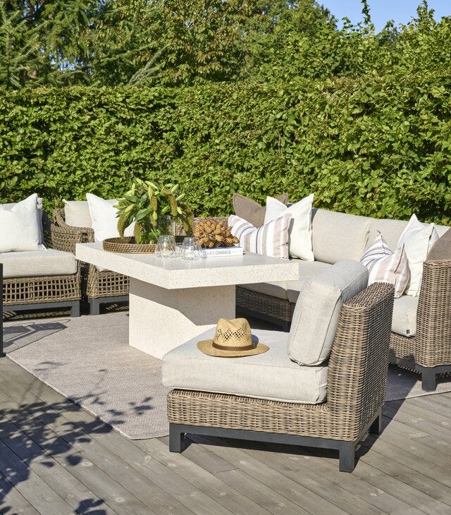 Elegant loungegruppe ute i kunstrotting og beige tesktil med sofabord i terrazzo fra Halvor Bakke hagemøbler