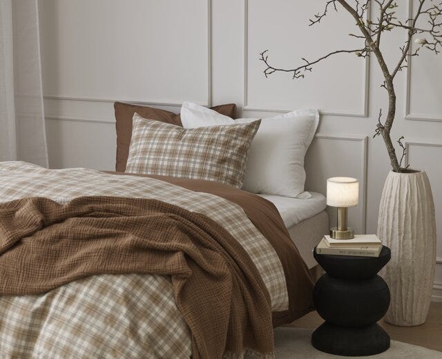 Beige rutete flanell sengesett i oppredd seng med musselin pledd