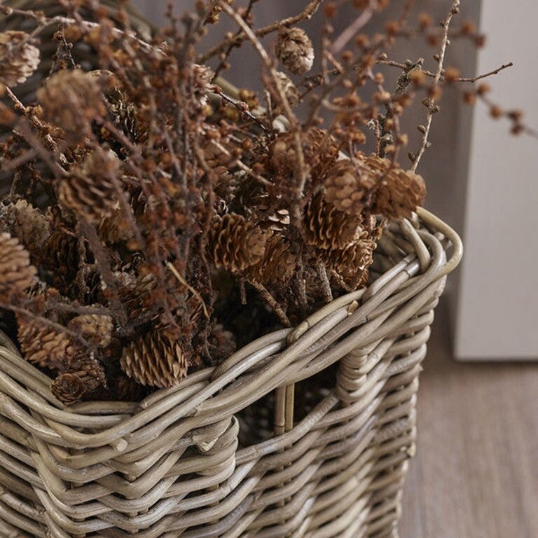 Kurv fylt med kongler og tørket naturpynt gir et rustikt og lunt uttrykk i rommet – like fint i gangen som ved peisen.