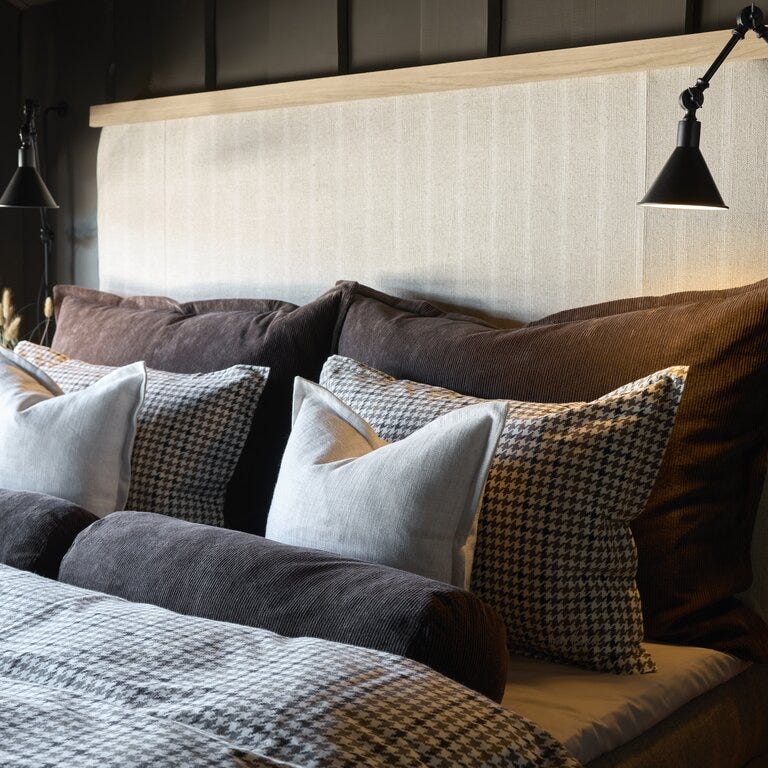 Soverom med hotellinspirert oppredning, tekstiler i jordtoner og innebygd belysning etter oppussing i Setesdal