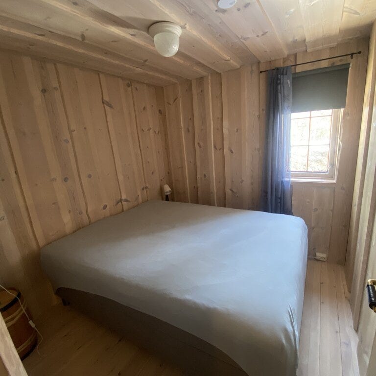 Lite soverom i hytte med dobbeltseng og ubehandlet furupanel på vegger og tak før oppussing i Setesdal